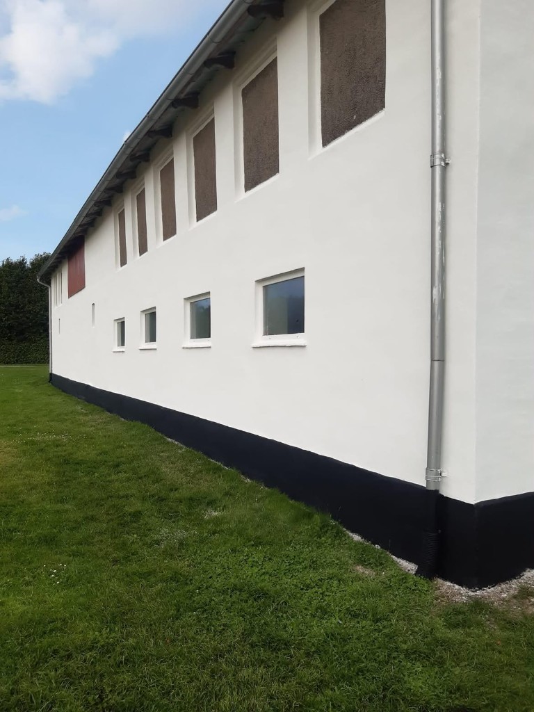 Facaderenovering, hvidpudset facade med sort sokkel